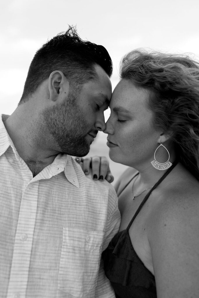 Black and white photo of a couple posing on the beach