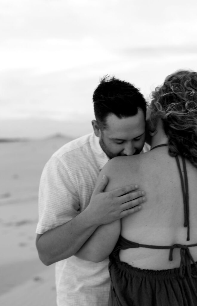 Black and white photo of a couple posing on the beach