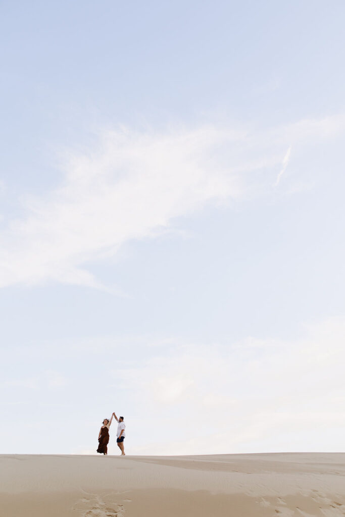 Couple dancing on the beach during their Silver Lake Sand Dunes engagement photos in MI