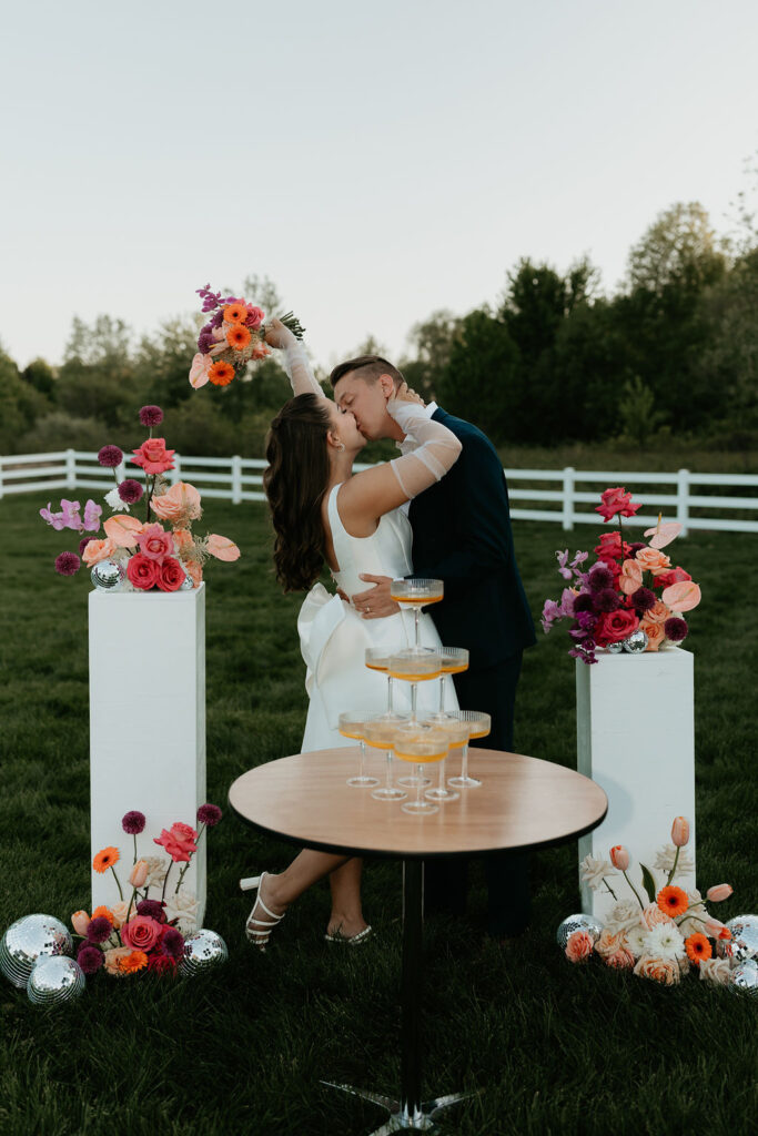 Bride and groom posing with their champagne table at Venue Bella Giornata