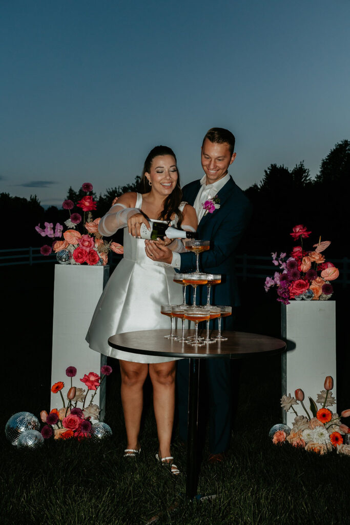 Bride and groom pouring into their champagne tower