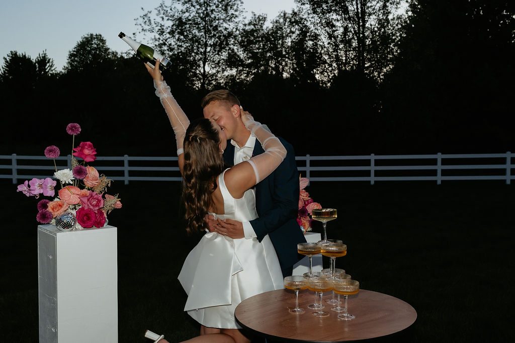 Bride and groom posing with champagne