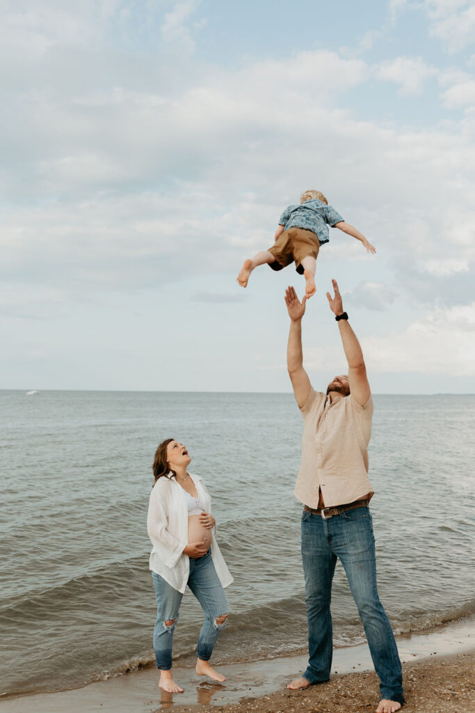 Family of three on Lake Huron during their Michigan Beach maternity photos