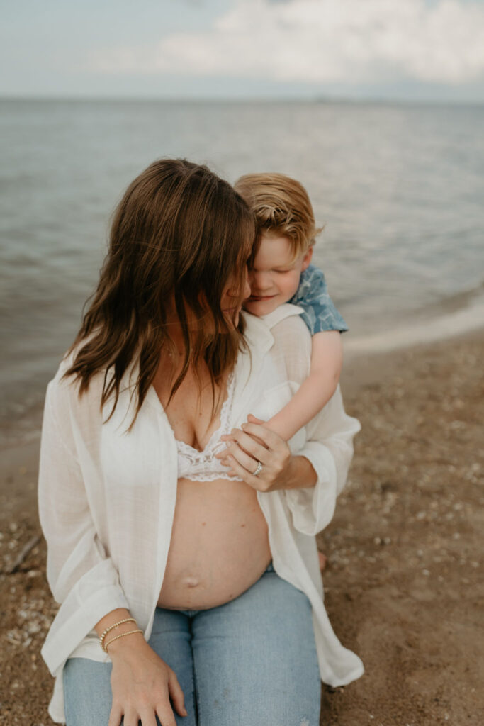 Mother and her son posing on the beach for her Michigan beach maternity photos on Lake Huron