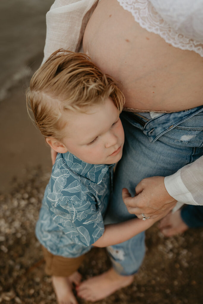 Mother and her son posing on the beach for her Michigan beach maternity photos on Lake Huron